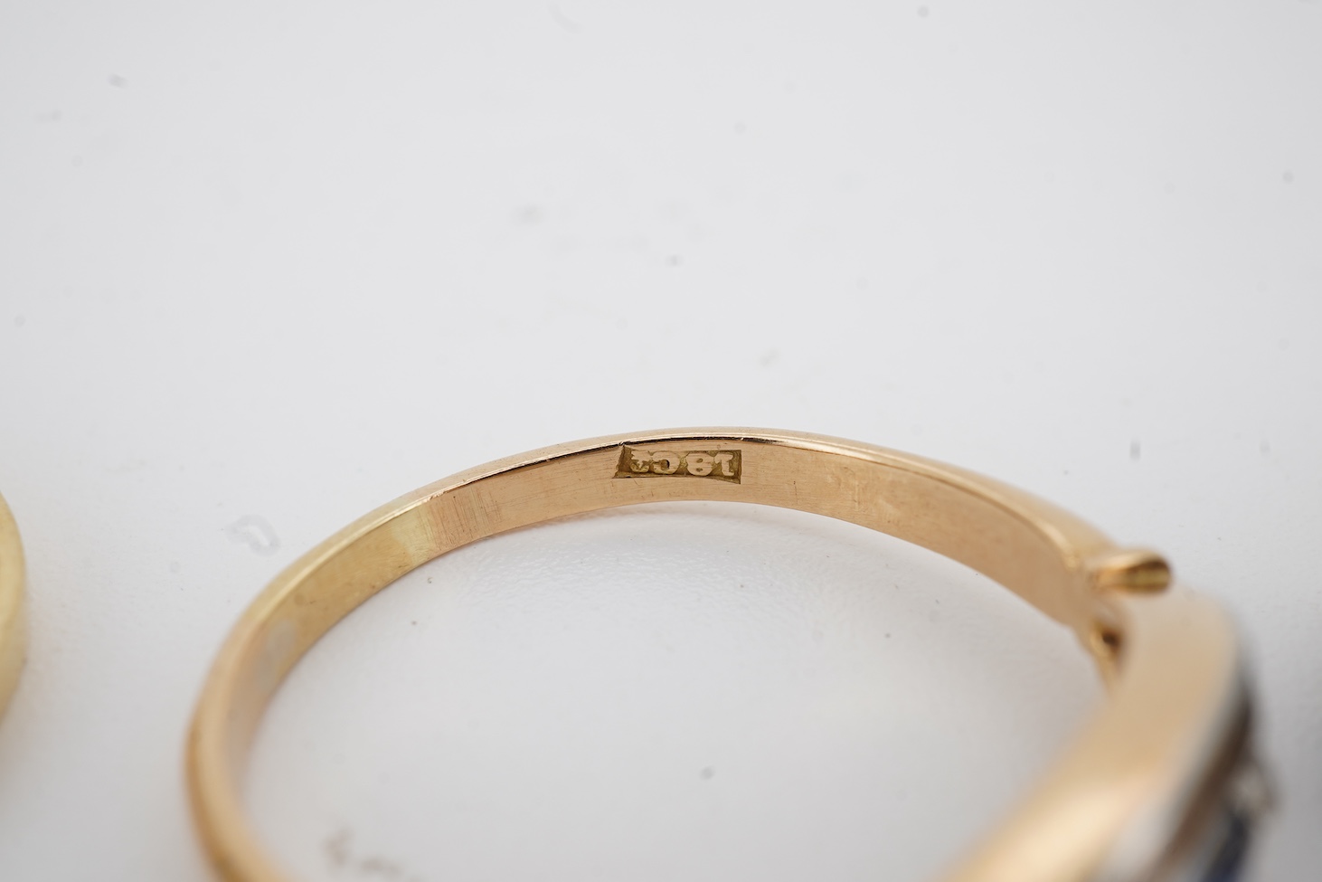 A modern 18ct gold, single stone sapphire and two stone diamond set ring, size O, an 18k, sapphire and diamond set oval cluster ring, size M/N and an 18ct, single stone sapphire and two stone diamond chip set navette sha